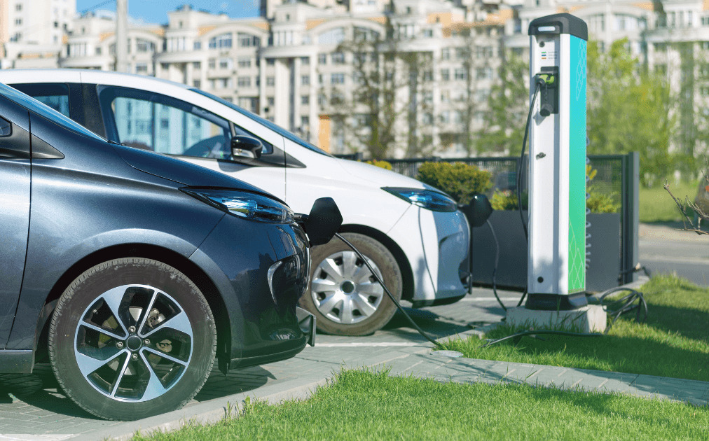 two electric vehicles charging in front of residential building